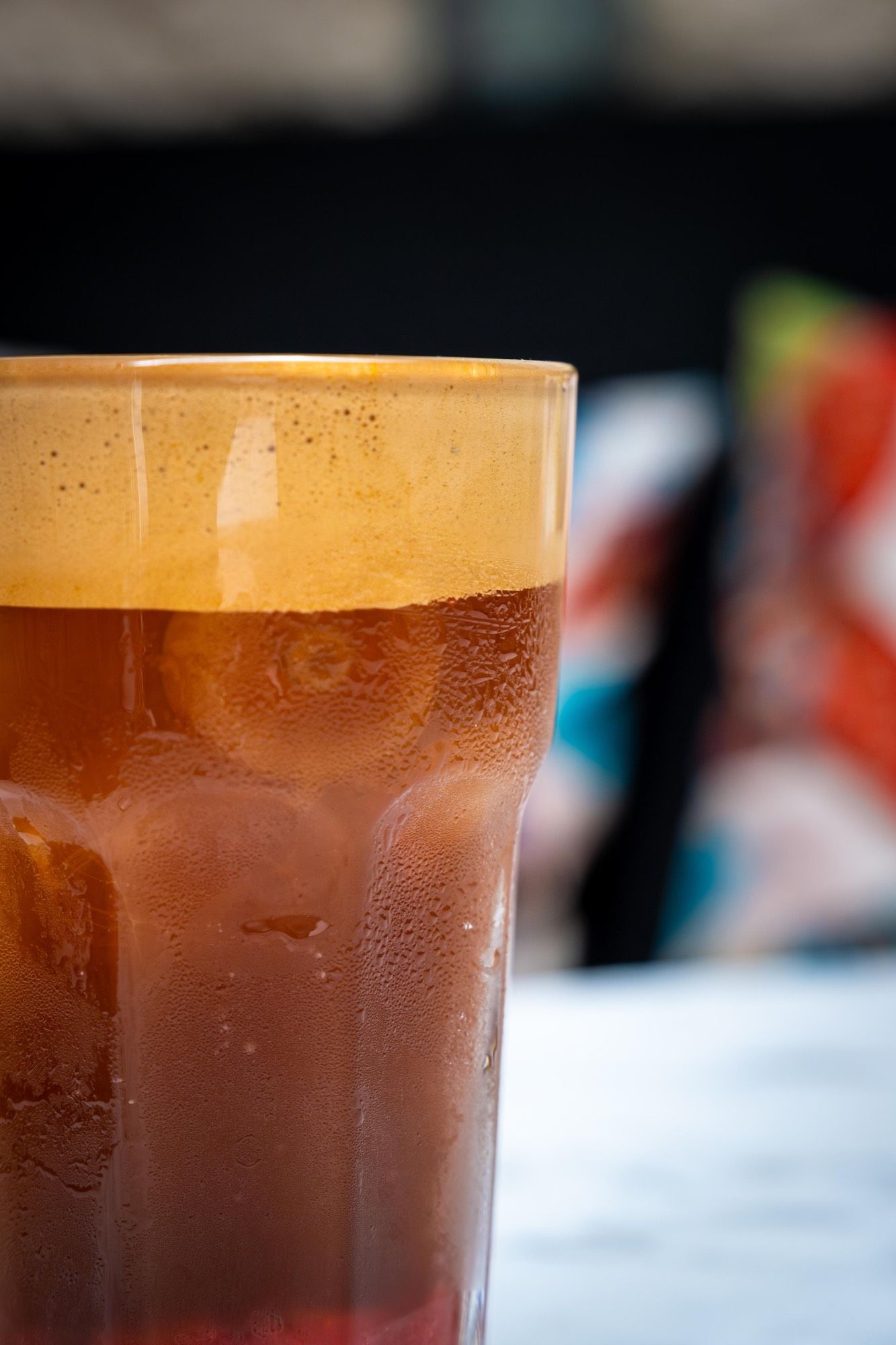 Espresso tonic glacé en très gros plan, crema mousseuse et condensation sur le verre